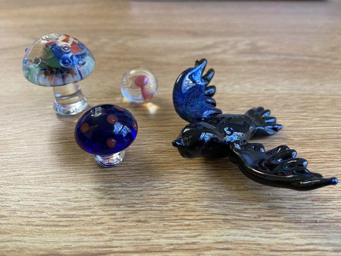 A glass bird and some glass mushrooms