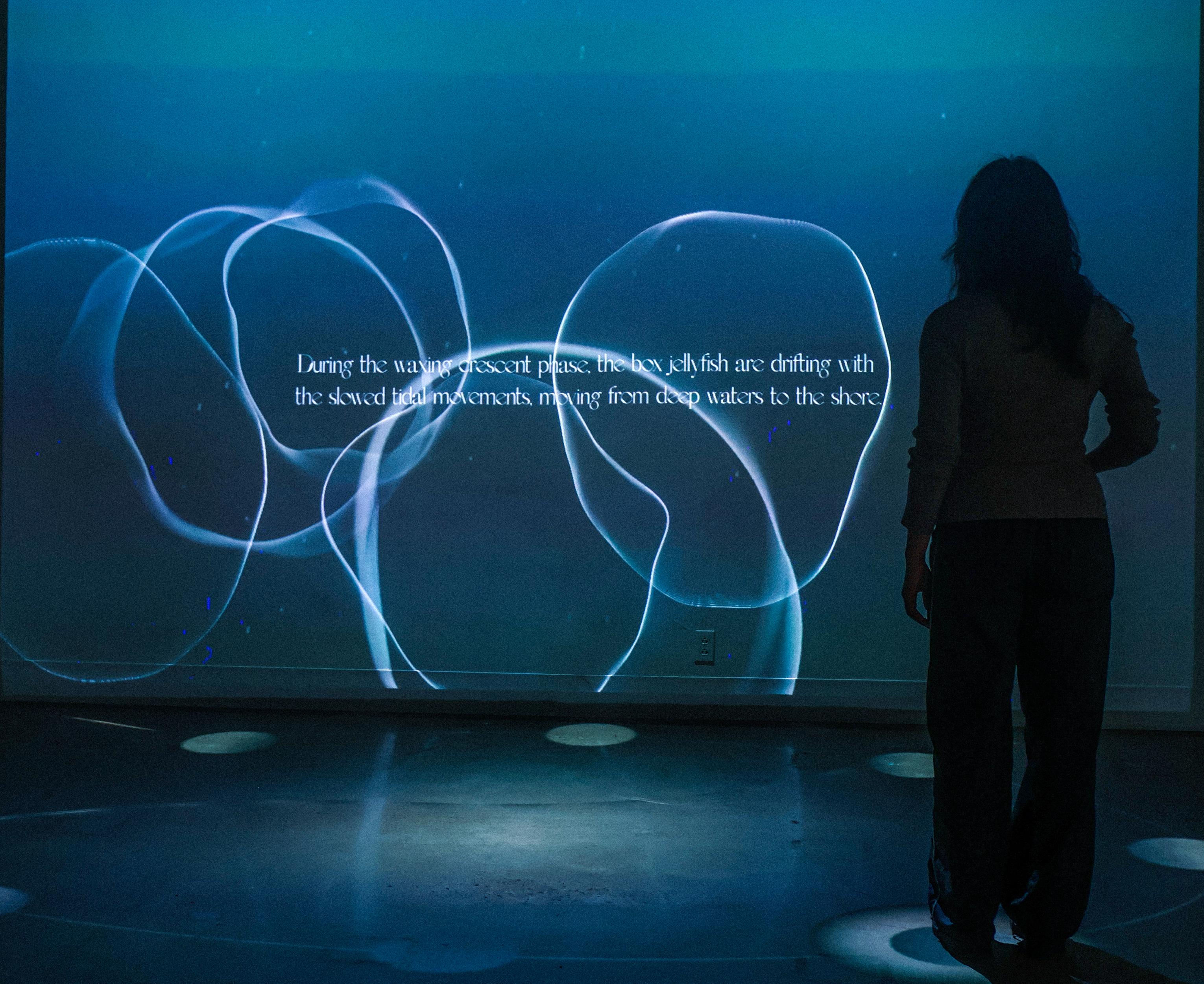 A woman standing in front of an image projected on a wall