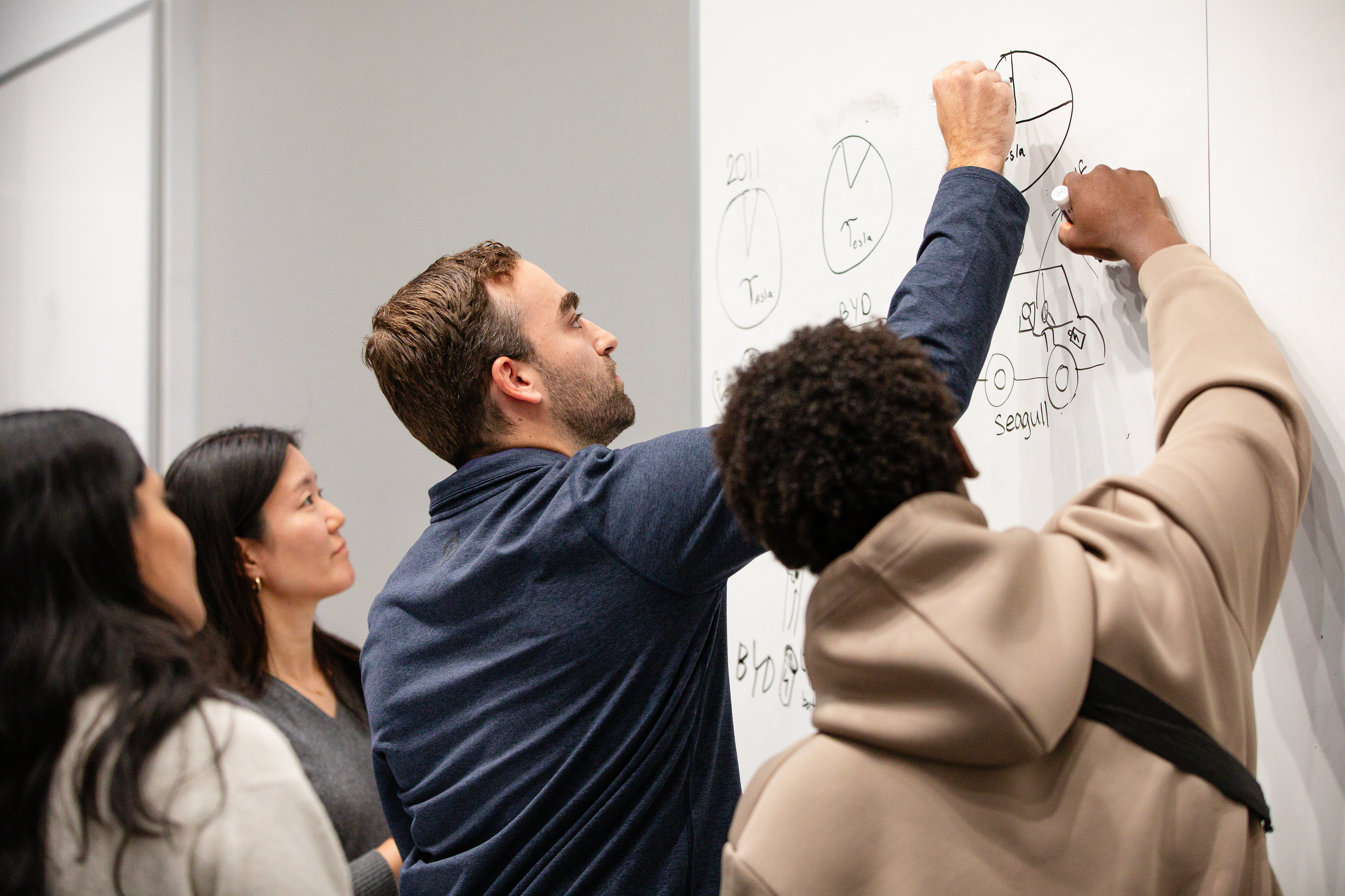 students draw together at the whiteboard