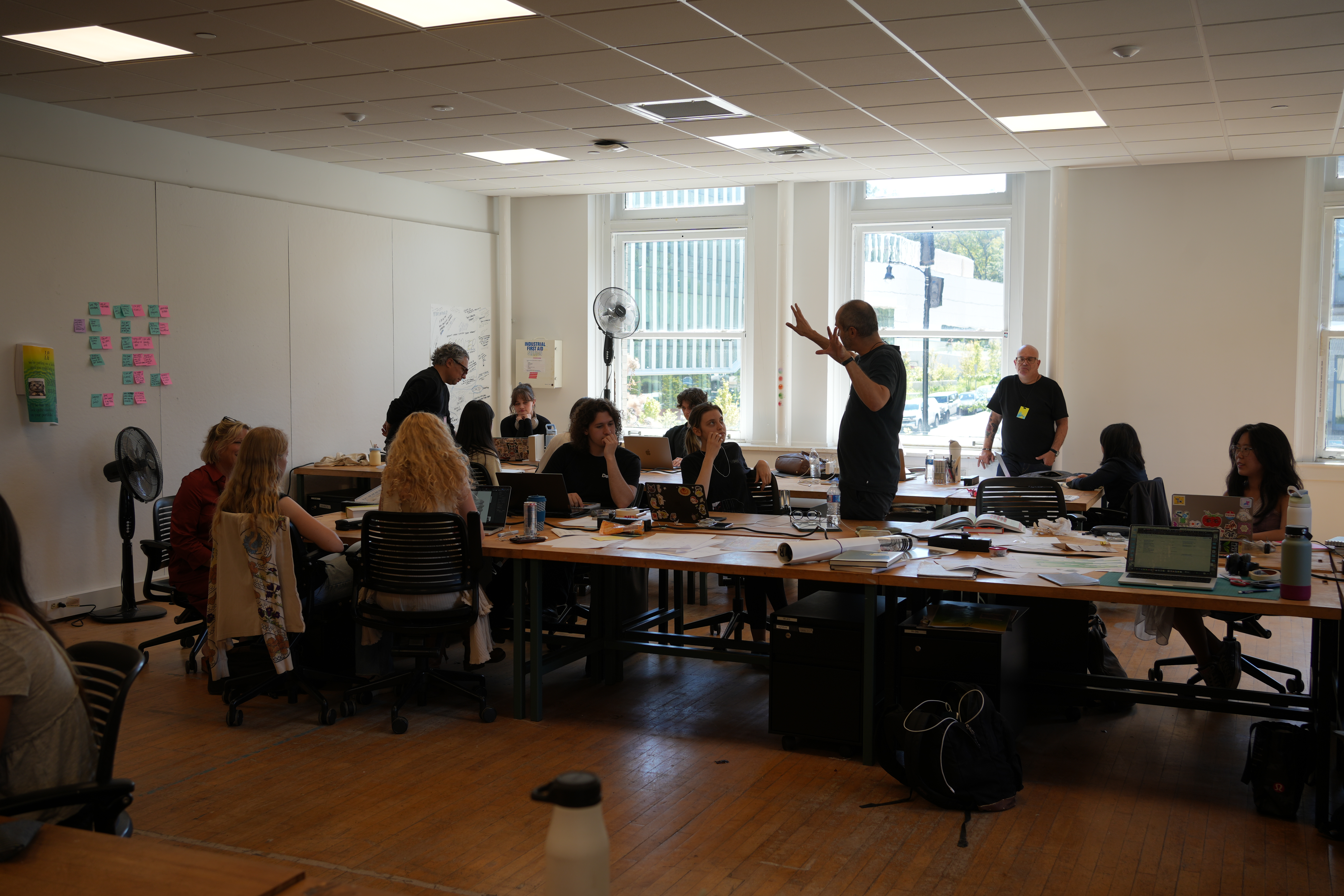 A man talking to a studio full of students