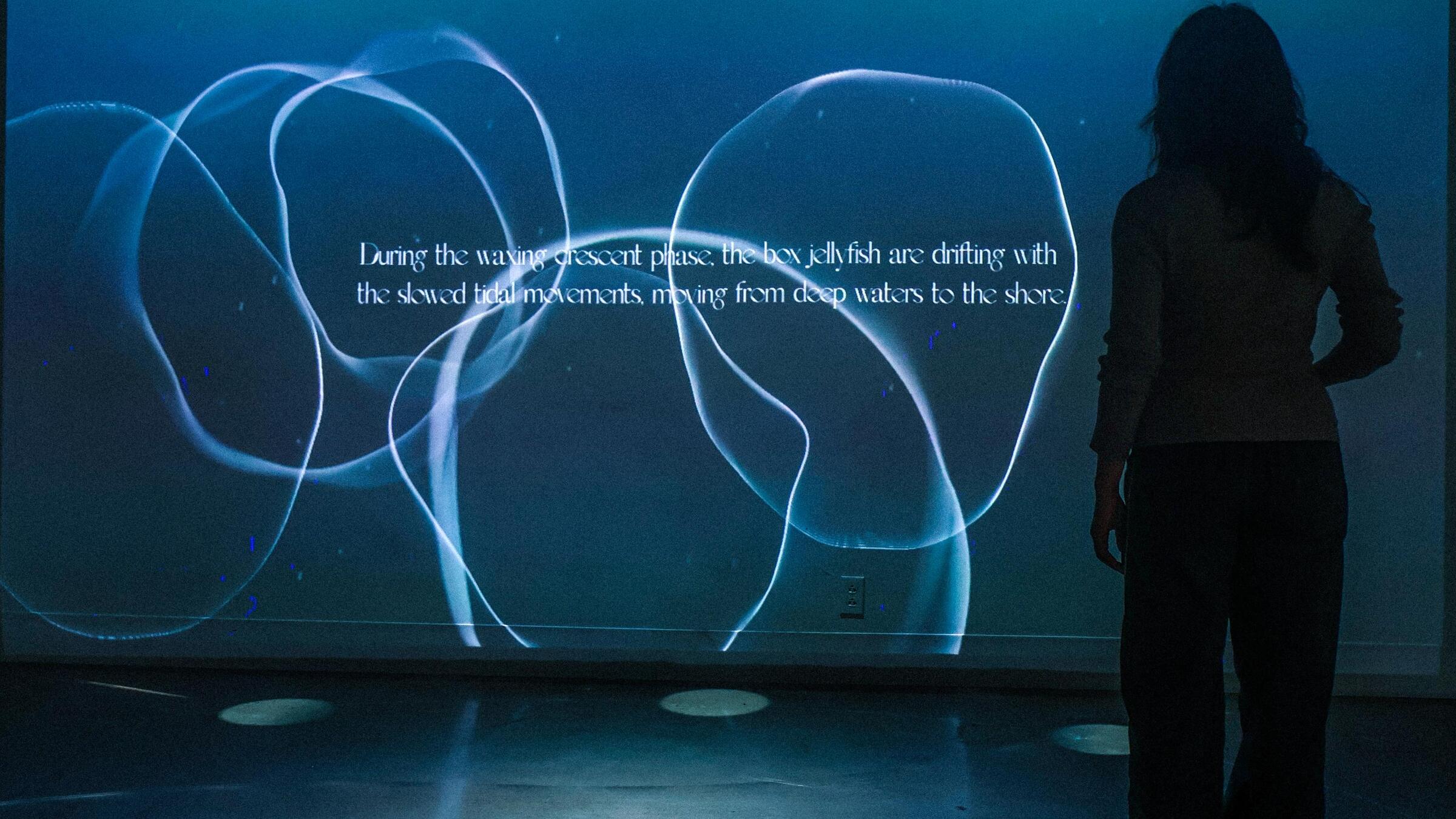 A woman standing in front of an image projected on a wall