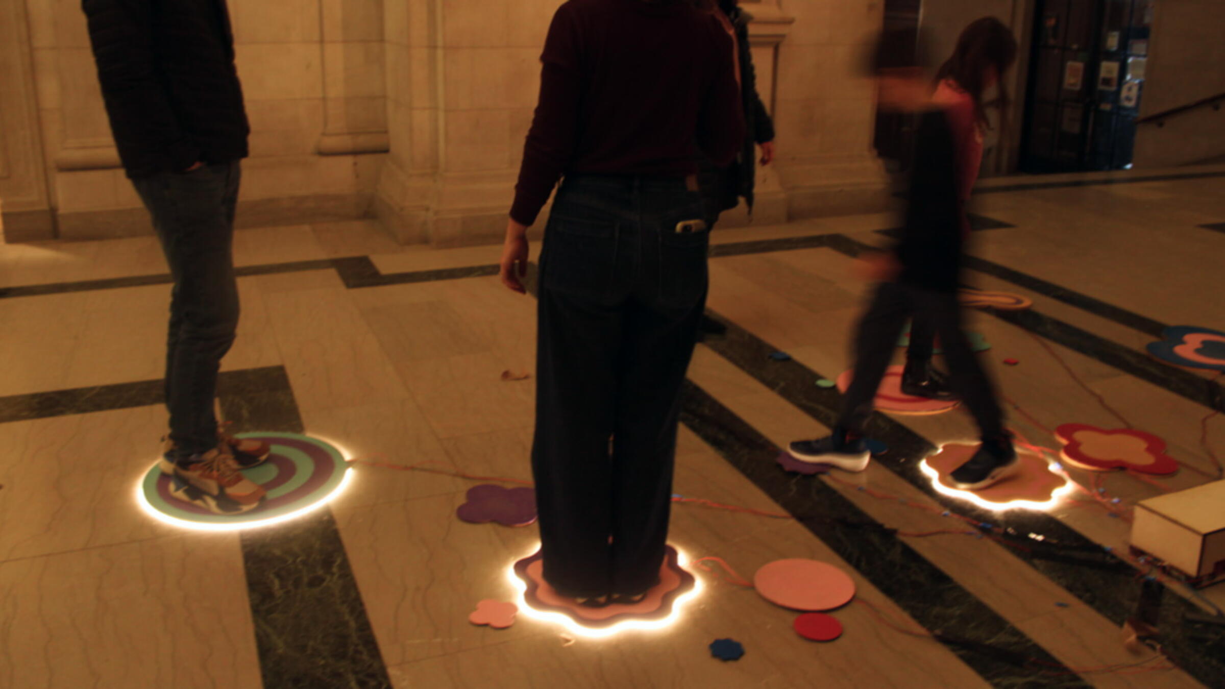 People standing on glowing pads