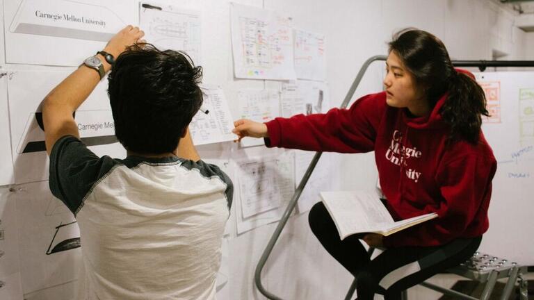 Two students working at a whiteboard