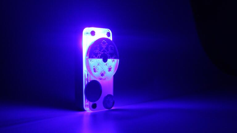 A blue flashlight with traditional Indian markings