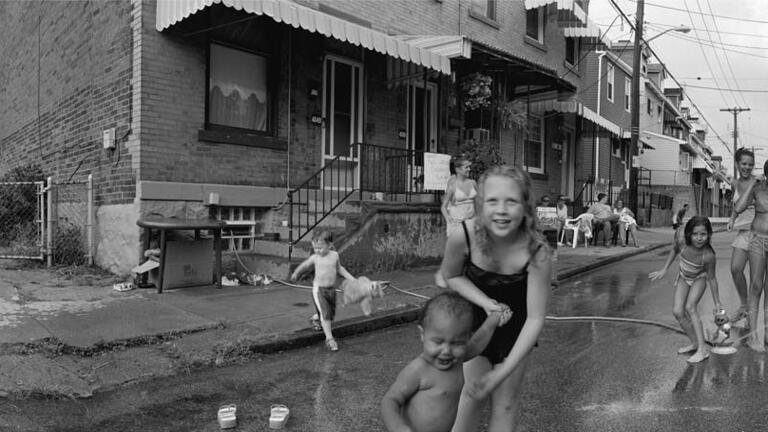 A large panoramic photo of people playing in the street