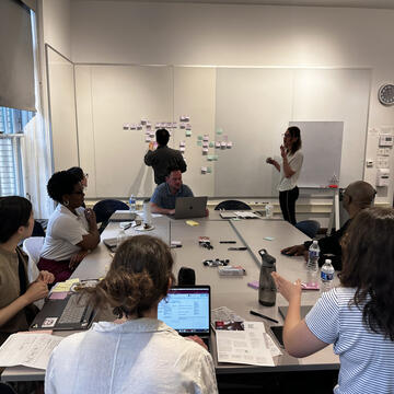 people gathered around a table in a conference room having a meeting