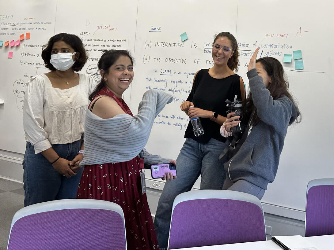 Master's Students laughing in the Grad Studio