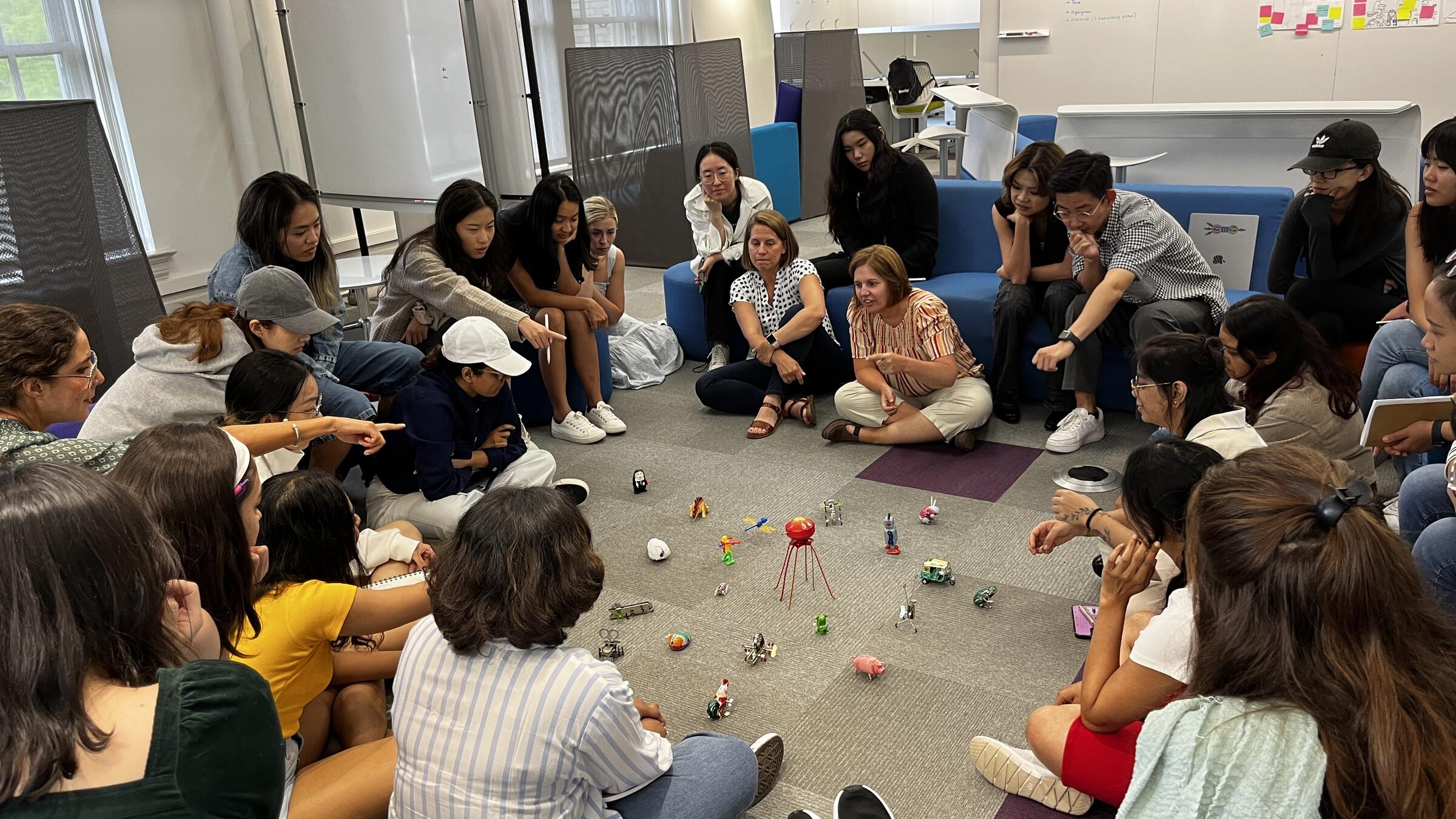 A group of master's students sitting on the floor and talking