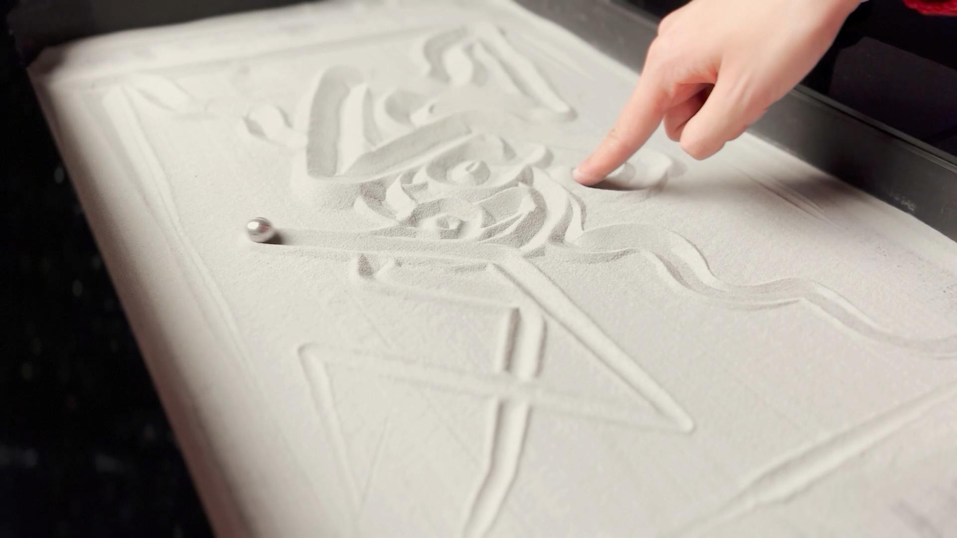 A marble making a drawing in sand